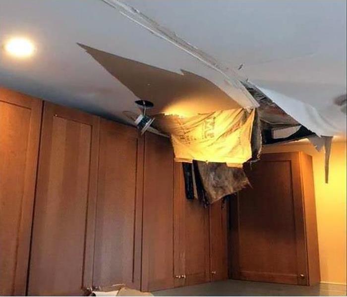 drywall ceiling collapsing with wood cabinets on the wall